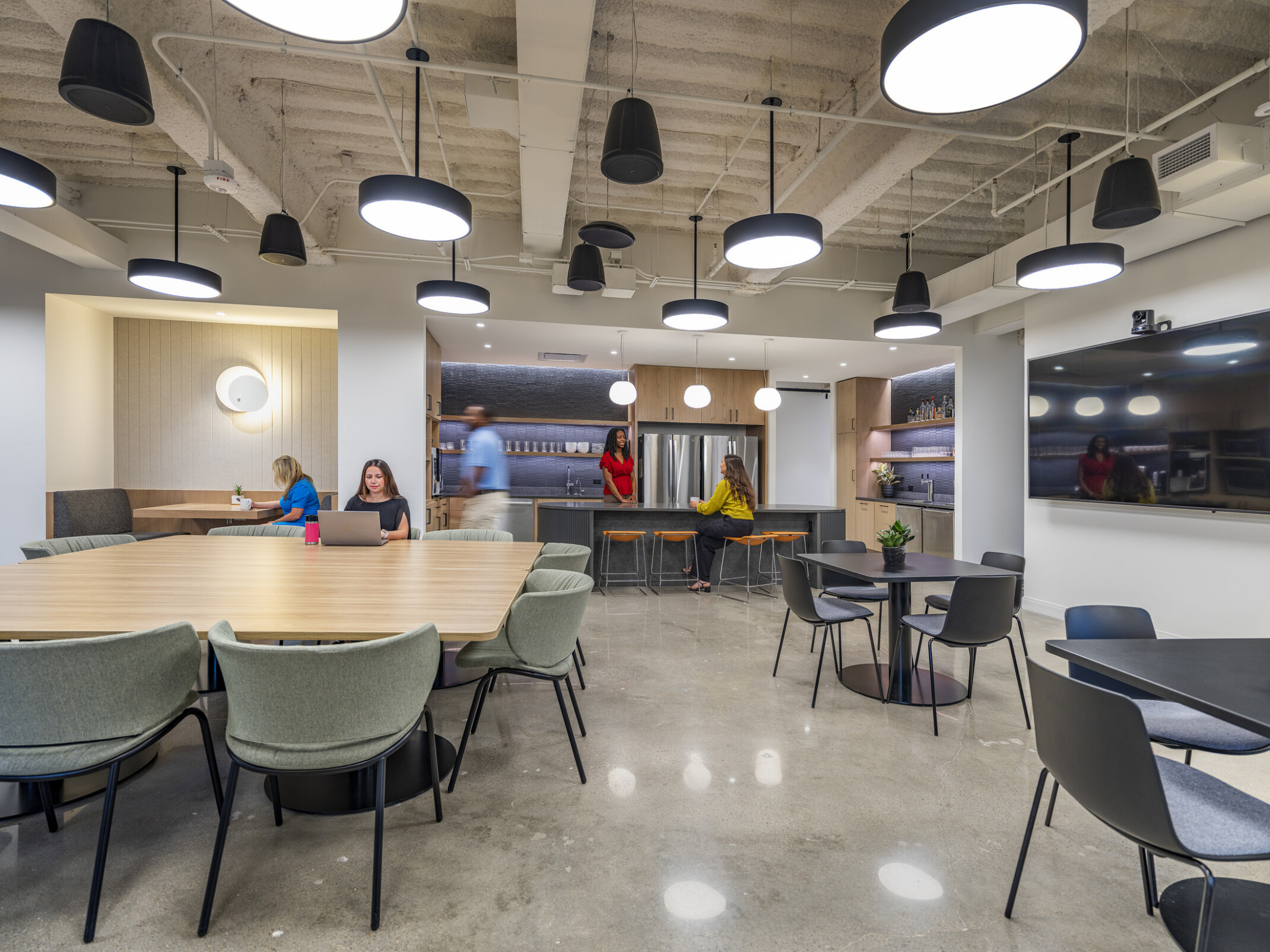 modern workplace kitchen with flexible furniture and people sitting and working