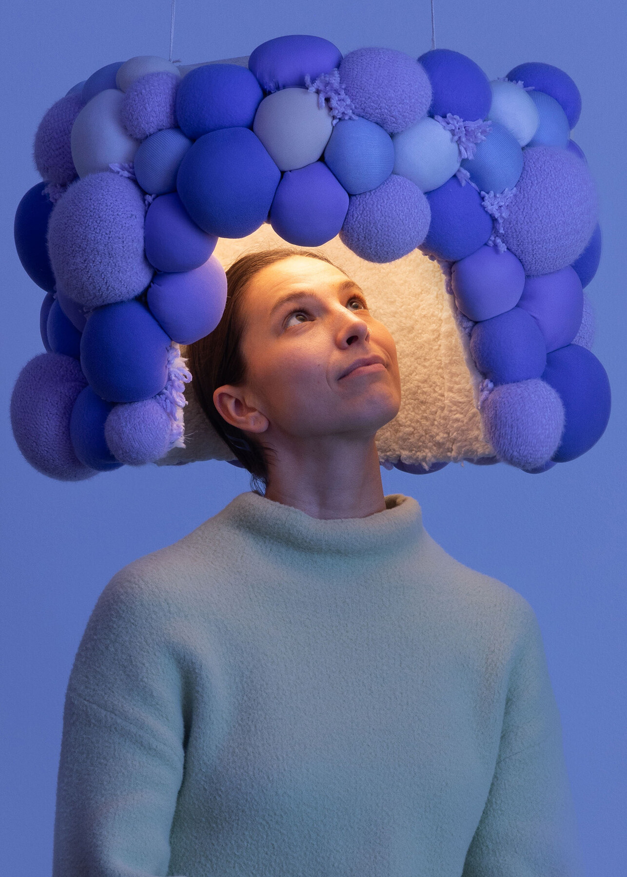 woman standing beneath a sound suppressing design feature; design for neurodiversity and hearing sensitivity, tactile in Venice
