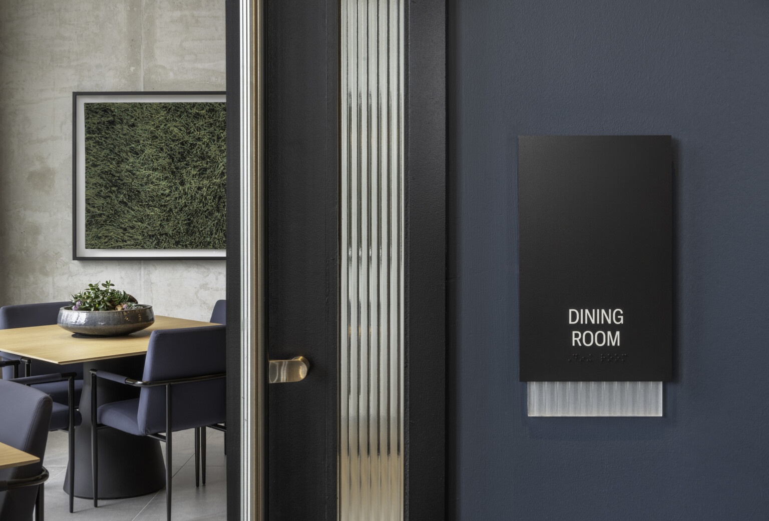 modern sign that says "dining room" with an open door to a room with a round table