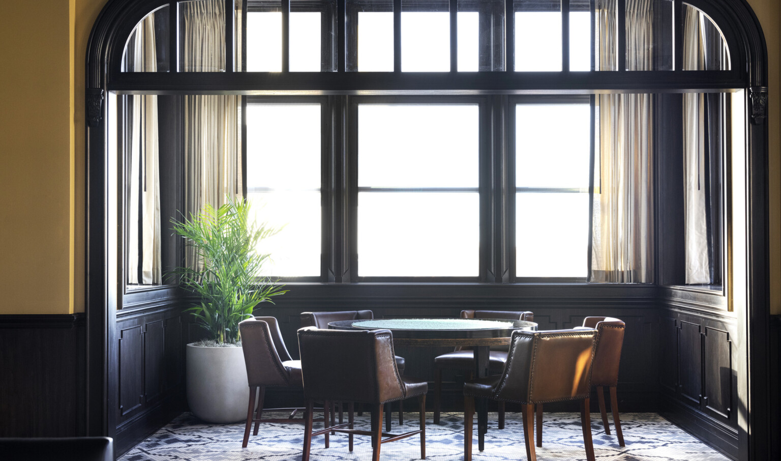 round table and leather chairs in front of a window