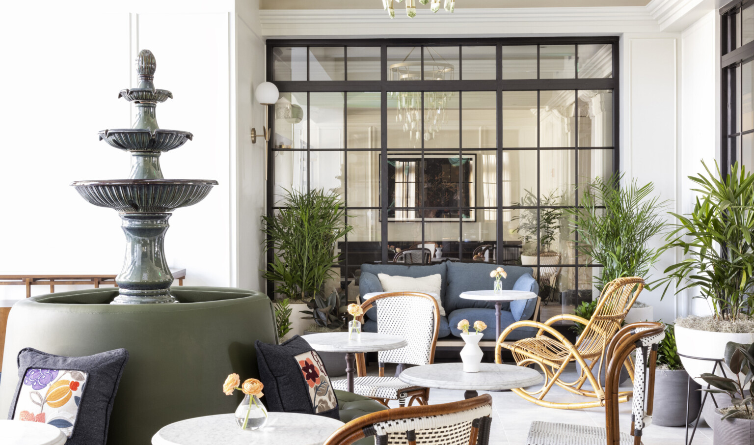 a variety of wicker and soft seating around an indoor tiered fountain