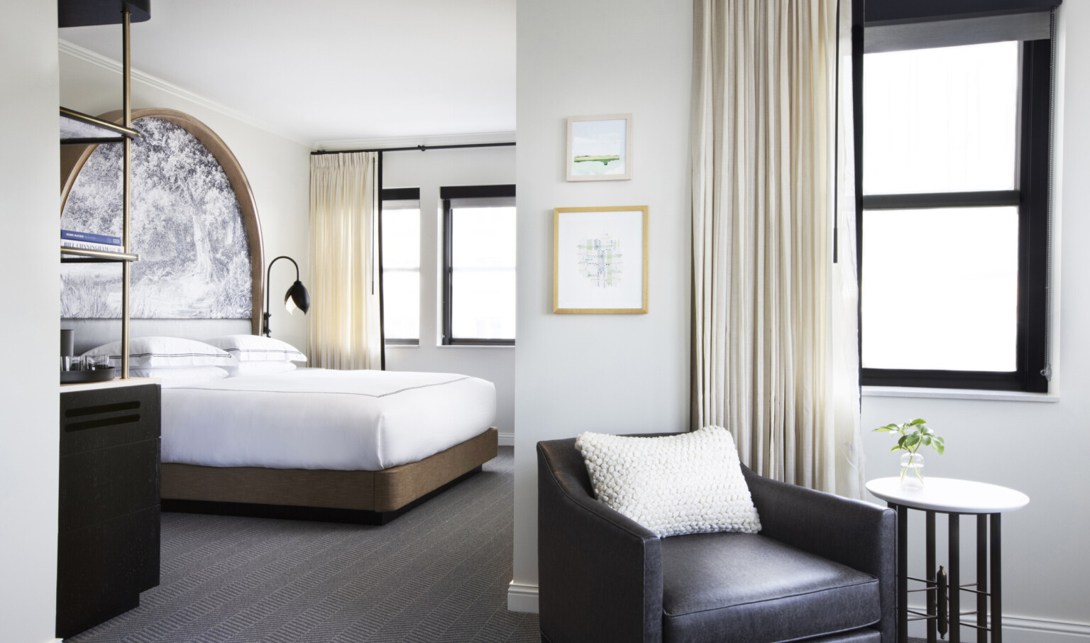 a leather arm chair and bed in a guest room