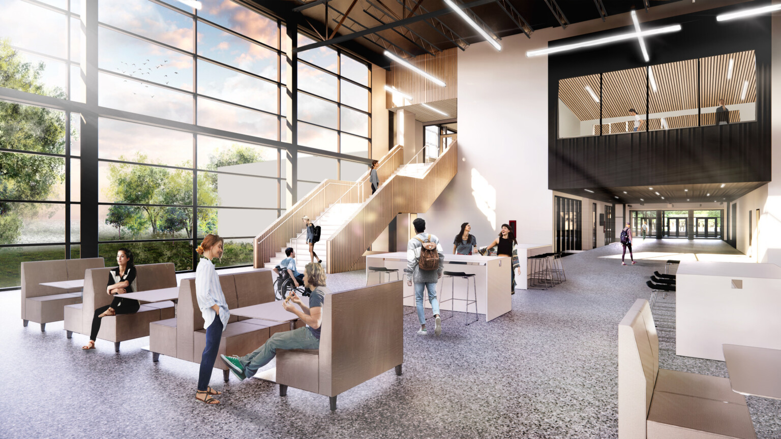 floor-to-ceiling windows provide natural light that helps provide focus for students and faculty, triple-height ceiling gives a sense of expansiveness, polished concrete flooring, light wood staircase, comfortable seating in muted creams, greys, and beiges promote a sense of well-being