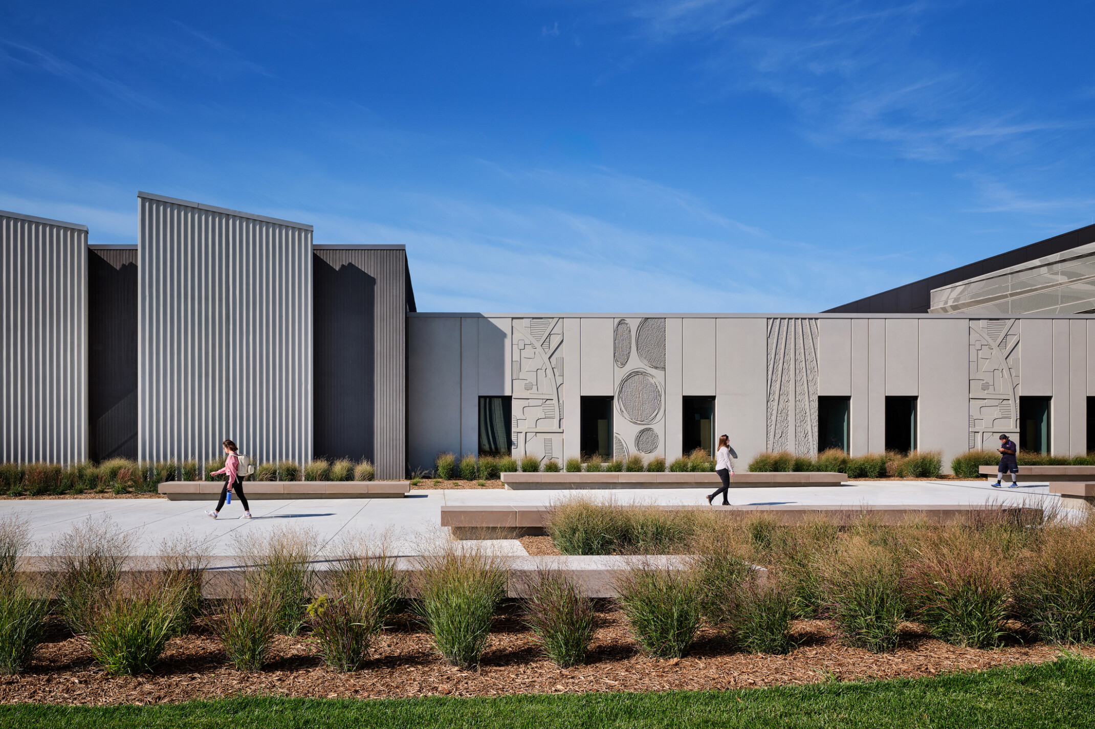 Beige colored single story building with shapes and artwork carved into the panels with modern angles