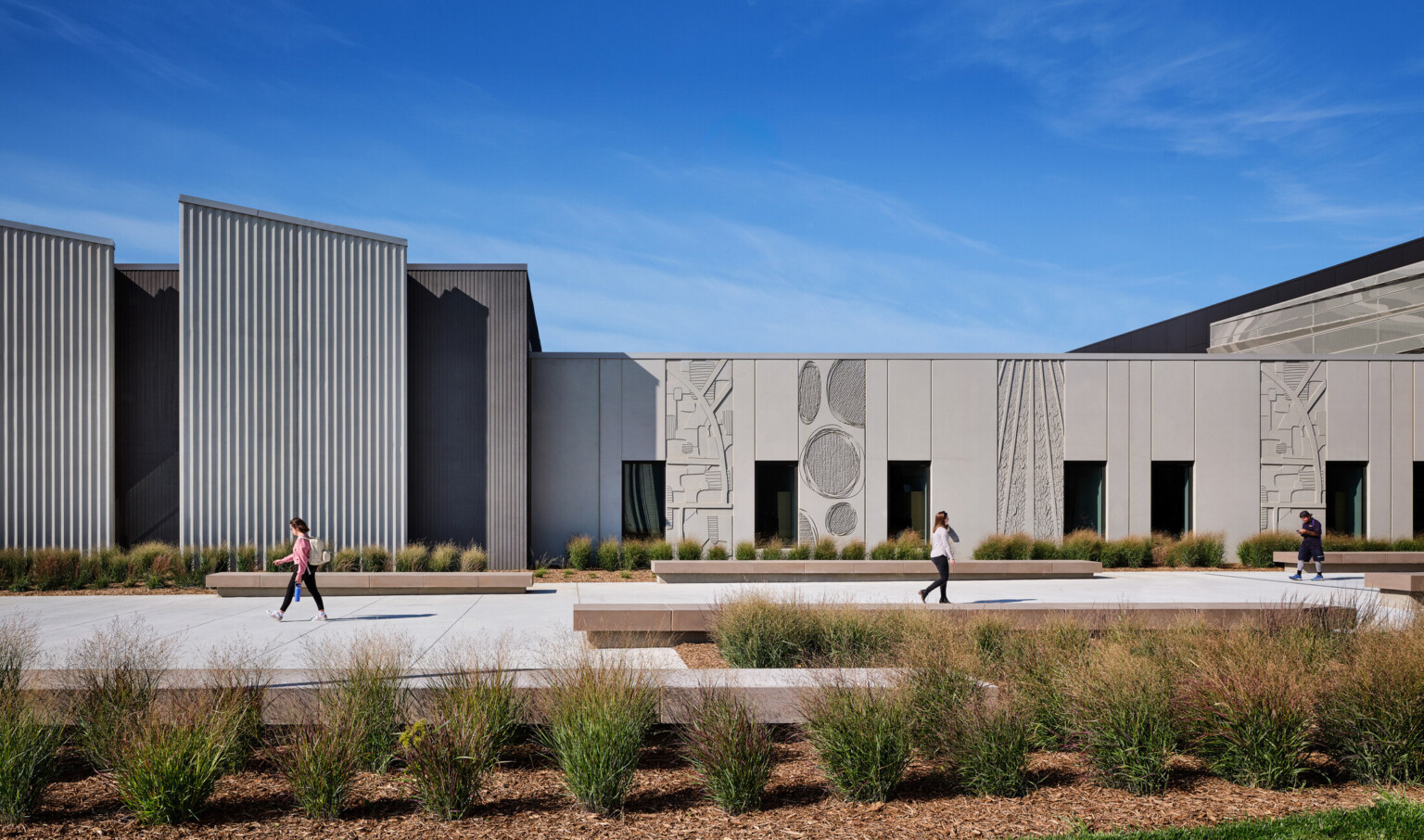 Beige colored single story building with shapes and artwork carved into the panels with modern angles Beige colored single story building with shapes and artwork carved into the panels with modern angles