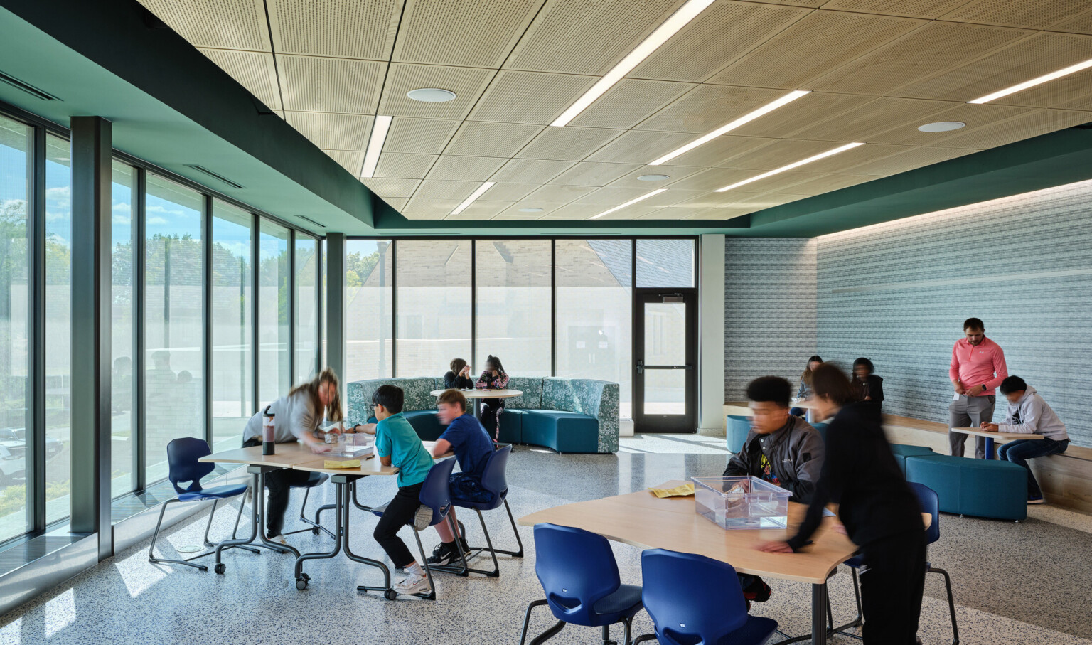 students in a classroom at Boys Town Education center; pod desks with 2-4 students at each; minimal distraction for trauma informed design students in a classroom at Boys Town Education center; pod desks with 2-4 students at each; minimal distraction for trauma informed design