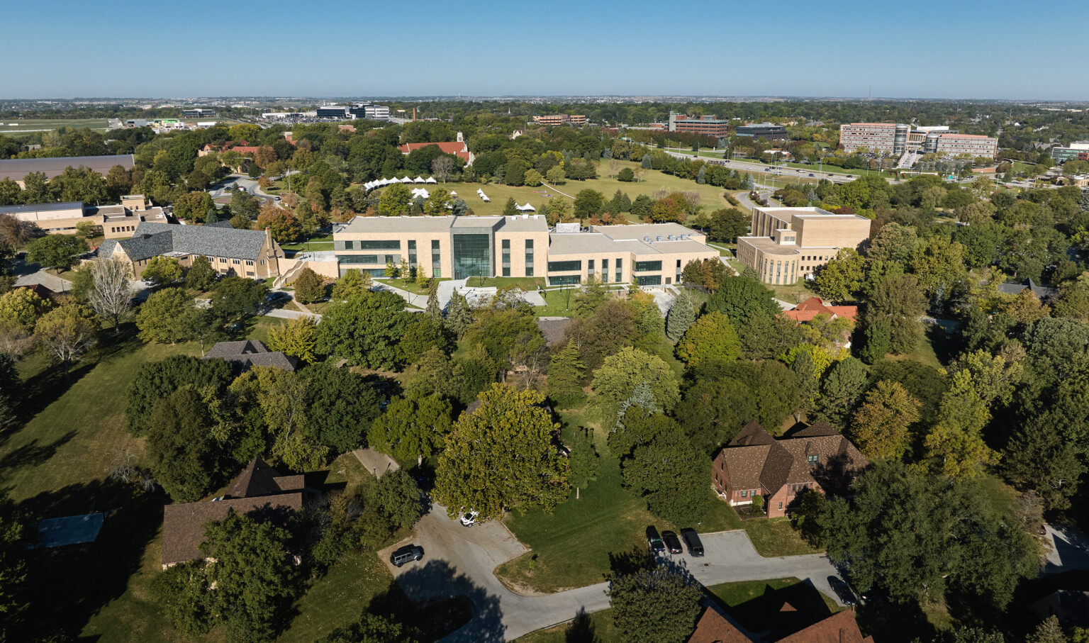 Boys Town Education Center aerial view; large white school building surrounded by trees and walking paths; greenspace and welcoming trauma informed design