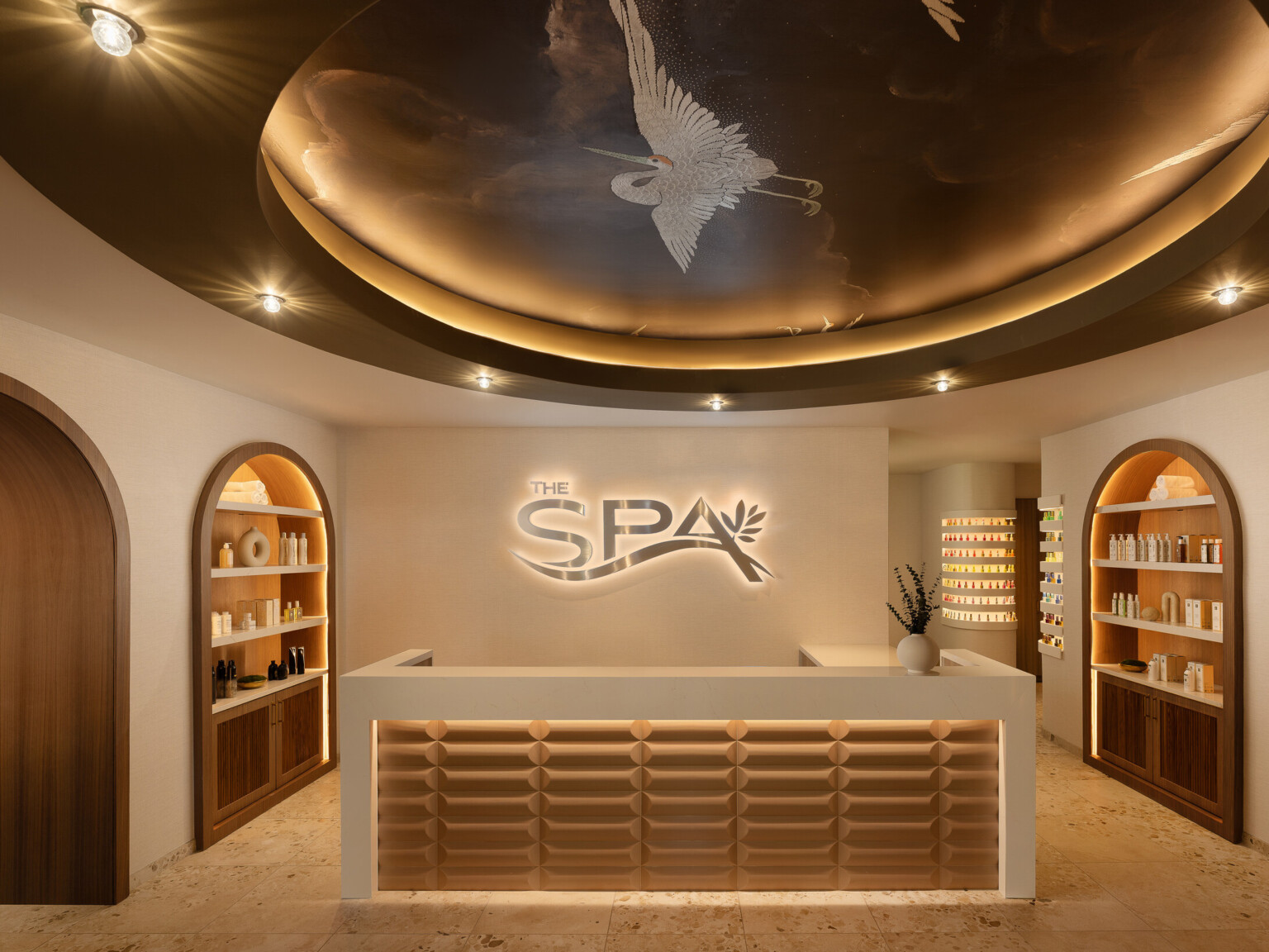 Grand Island Casino Resort at Fonner Park Spa entrance and reception desk with neutral, calming tones; circular lighting above front desk with spa logo on the back wall