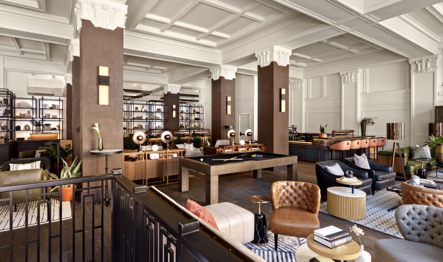 Seating area in the Surety Hotel with wood pillars and white stone capitals in white room with recessed ceiling details