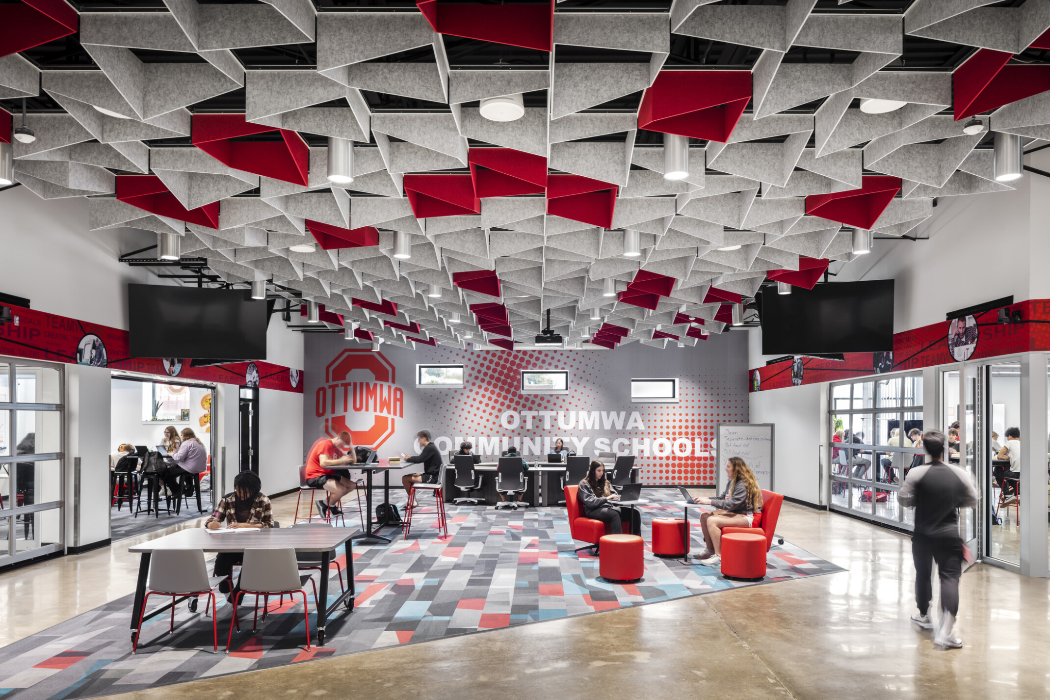 Ottumwa Career Campus interior seating area with grey and red baffles above mixed seating space