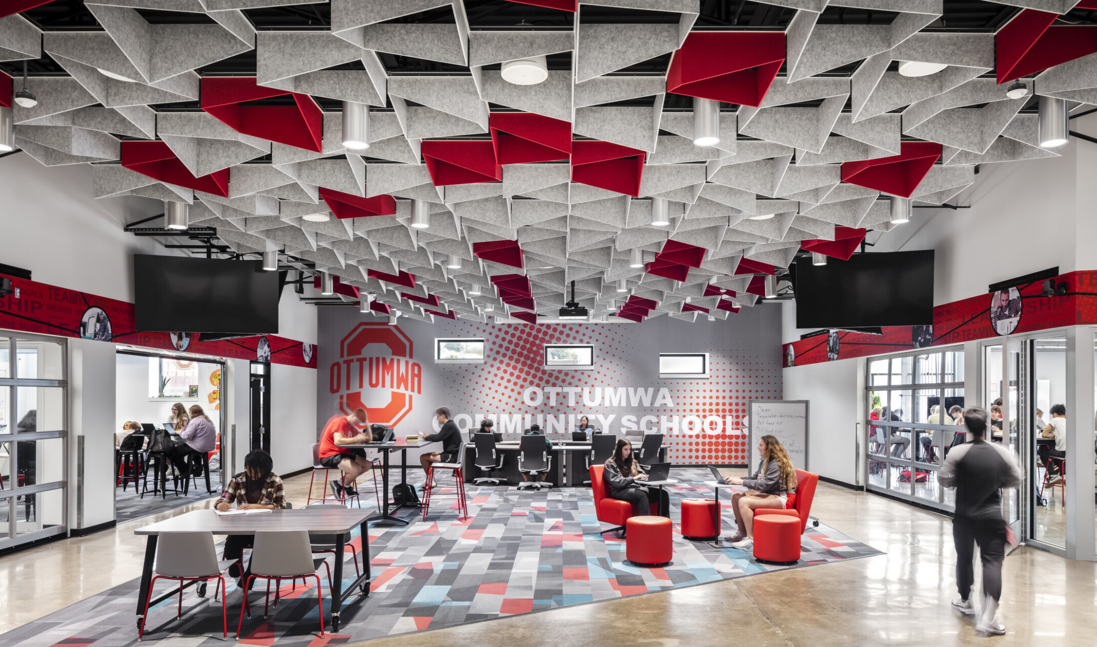 Ottumwa Career Campus interior seating area with grey and red baffles above mixed seating space
