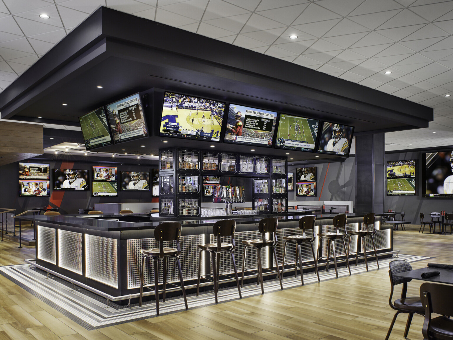 Q Casino modern sleek sports bar with multiple screens featuring games; mood lighting and feature lighting make for an inviting and relaxing space