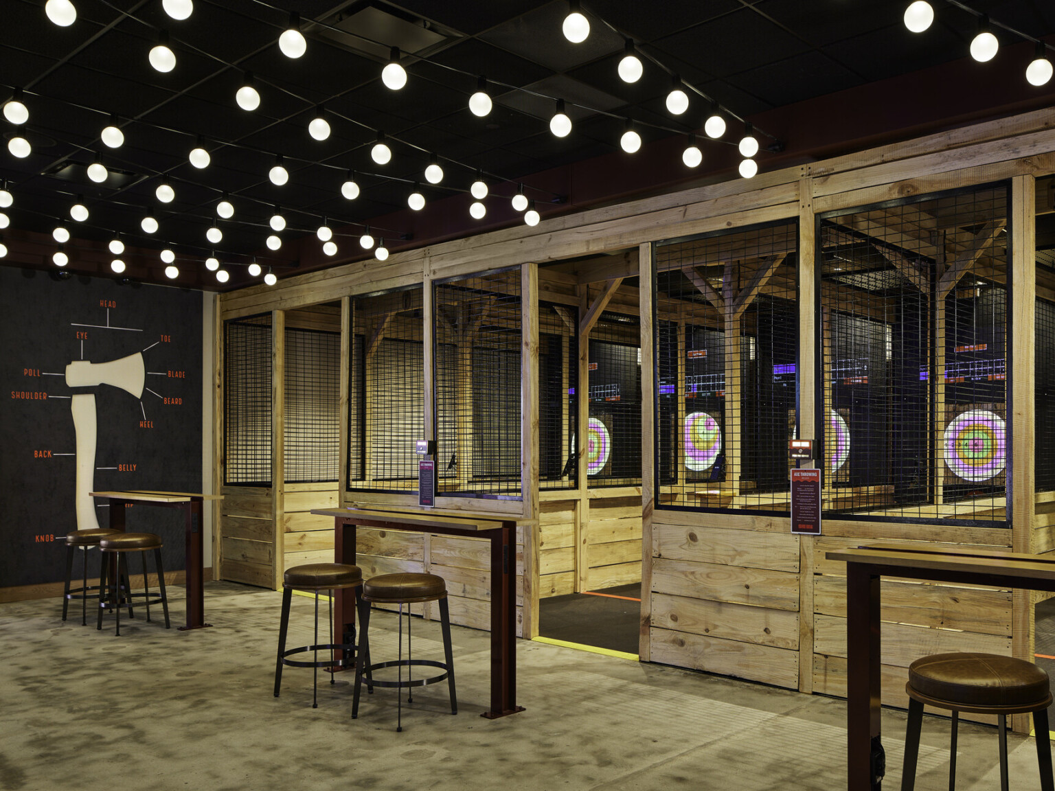 Q Casino interactive game space; axe throwing cages with bright illuminated targets; viewing area for nonplayers