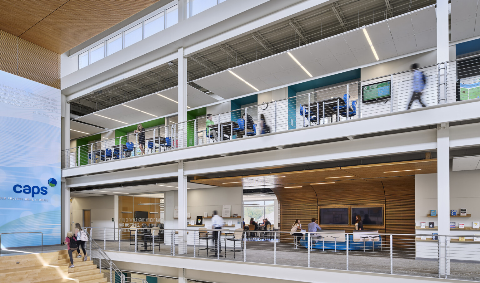 View of multiple stories with blue, green, and wooden accent areas with metal railings and light wood stairs