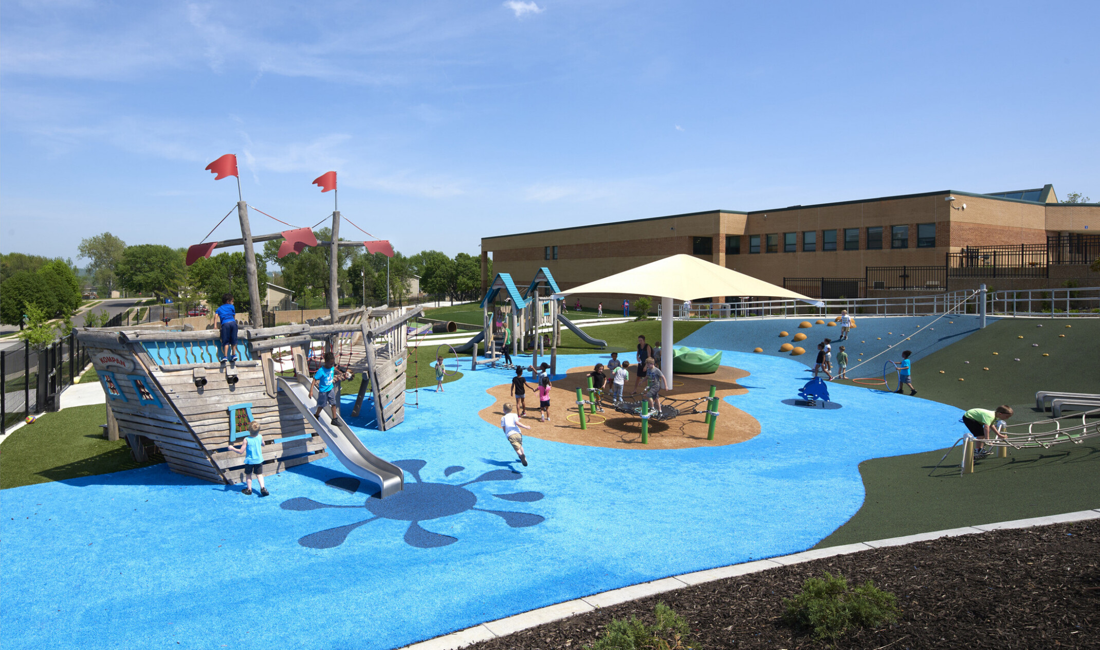 colorful ocean and pirate theme playground with multiple play structures with children playing