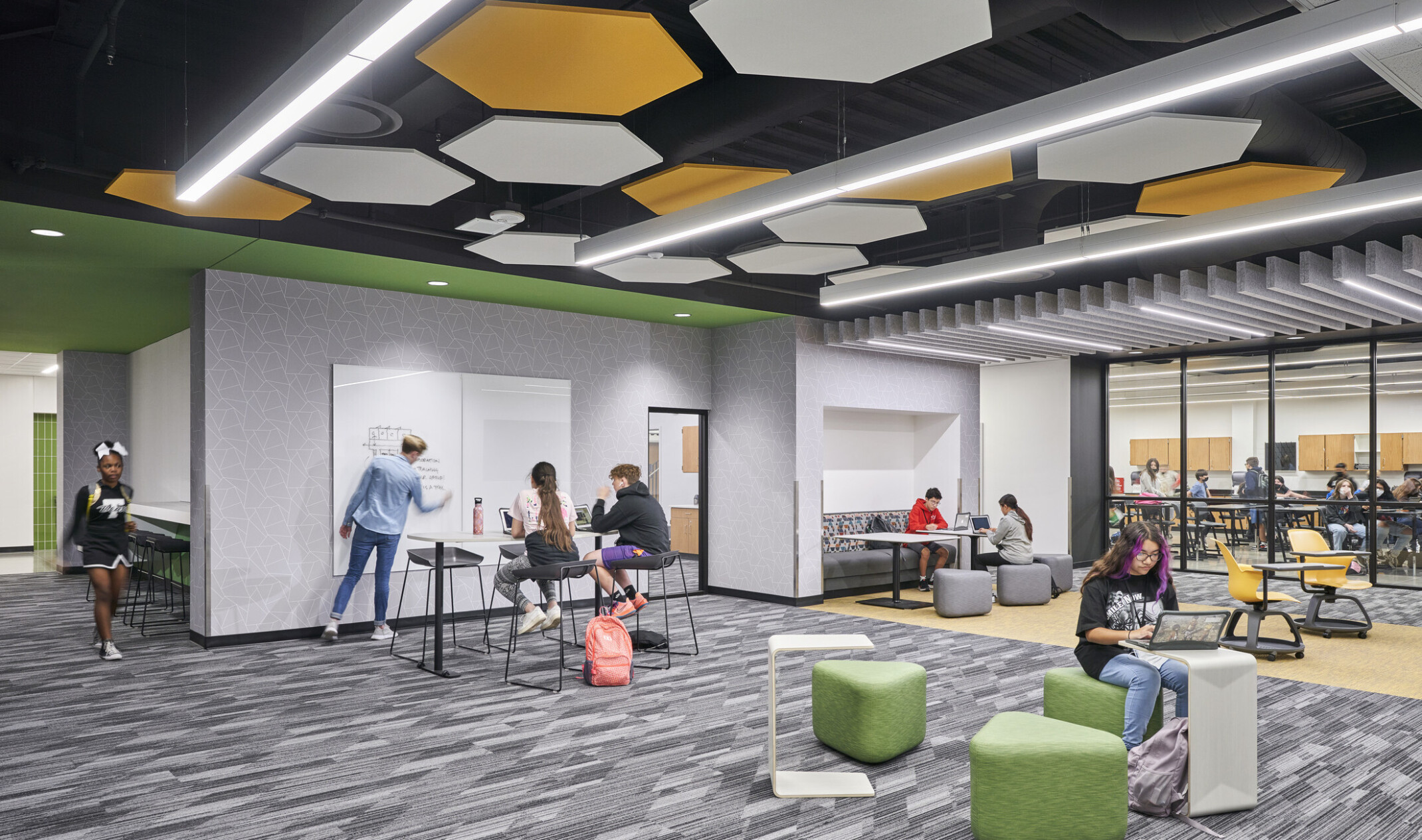 View of classroom with grey carpet multi-colored ceiling panels.