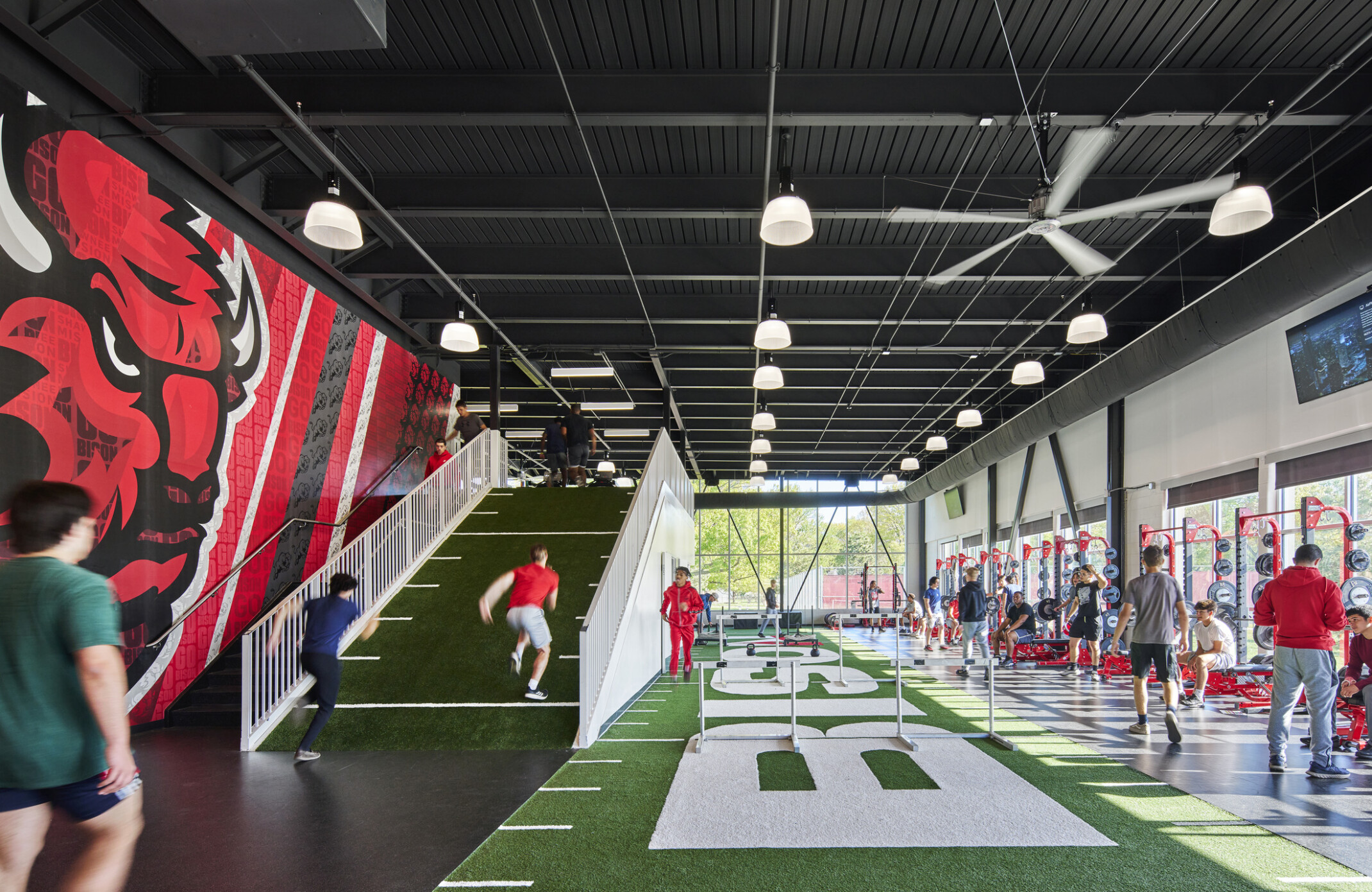 athletic performance space with large field simulated turf and weight machines