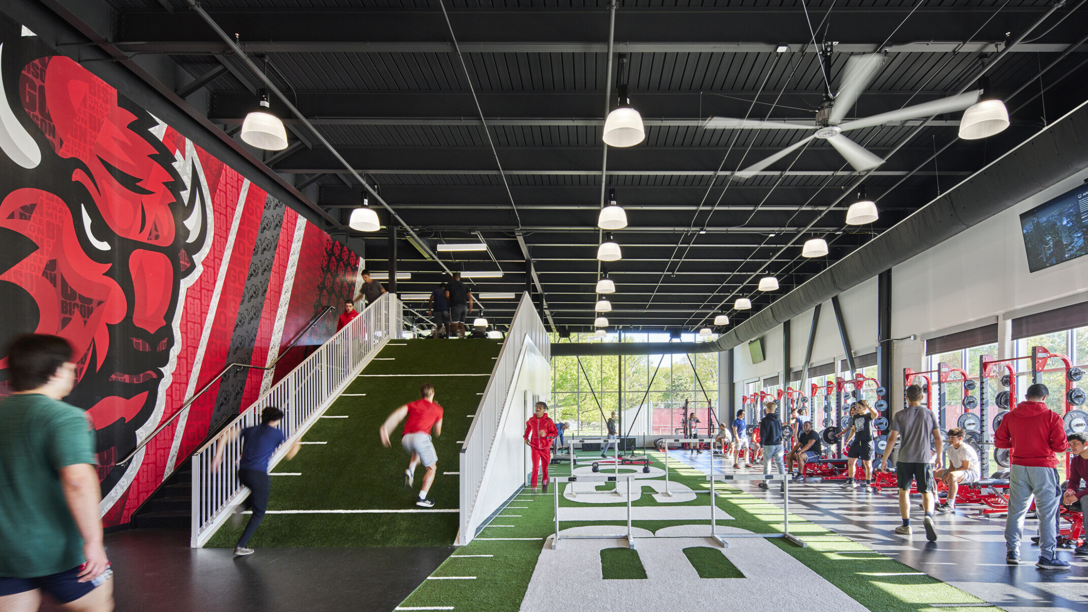 athletic performance space with large field simulated turf and weight machines
