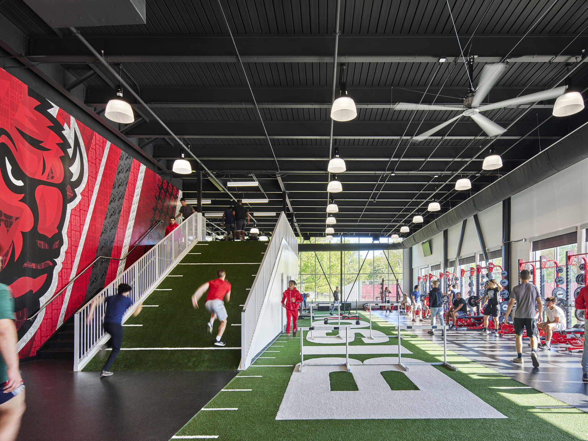 athletic performance space with large field simulated turf and weight machines