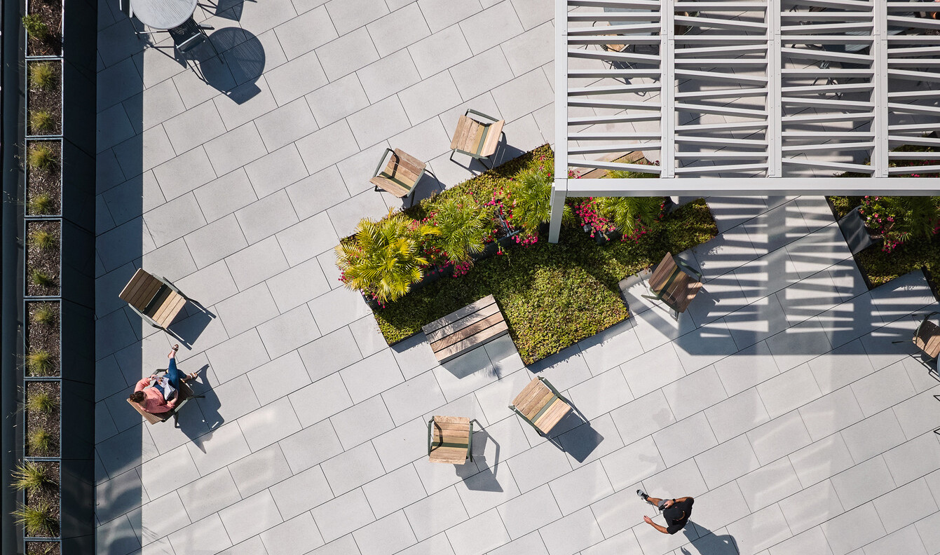 aerial view of a modern courtyard surrounded by greenery and a building awnings