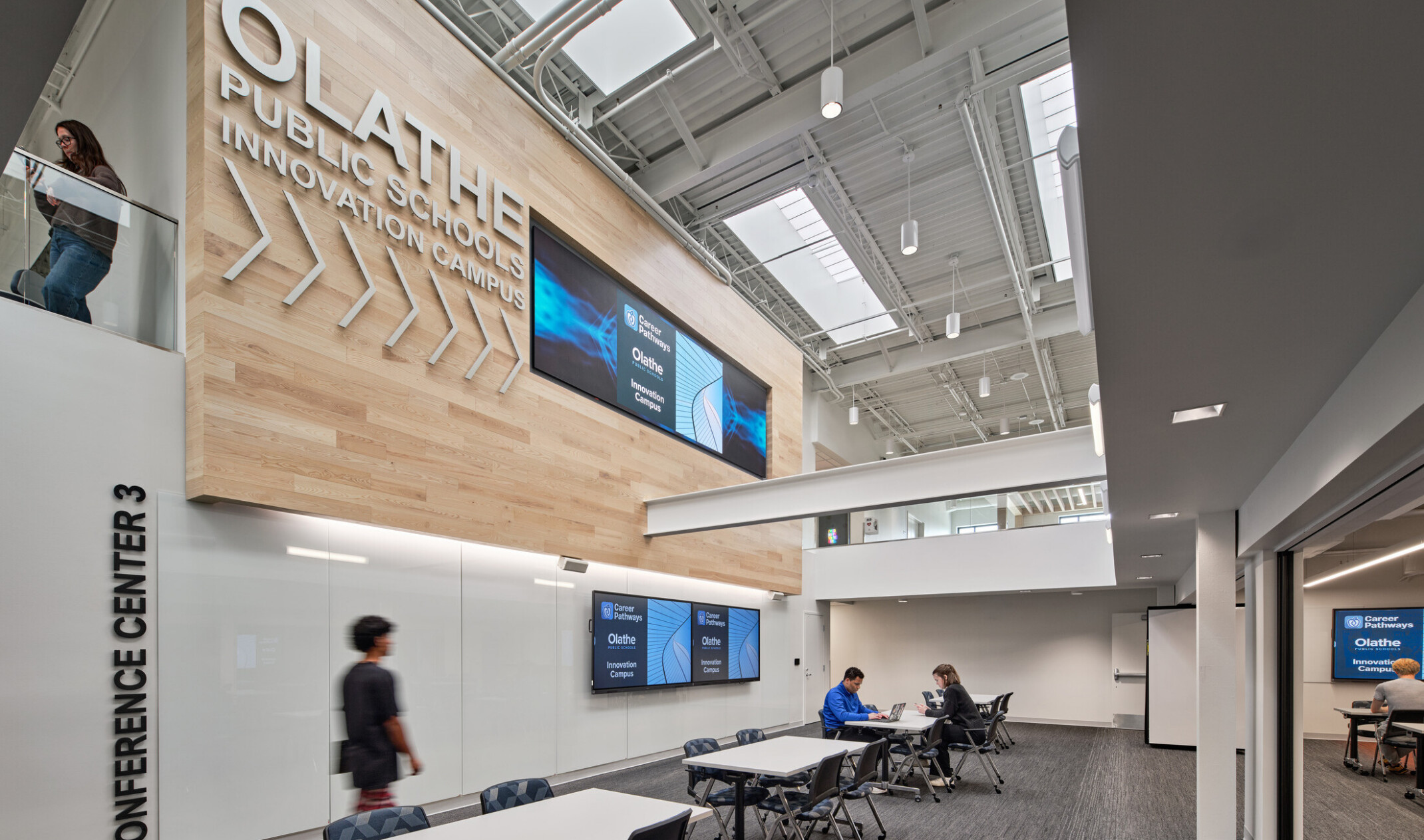 community study space in Olathe Innovation center with TVs on the wall and a communal seating space in the background