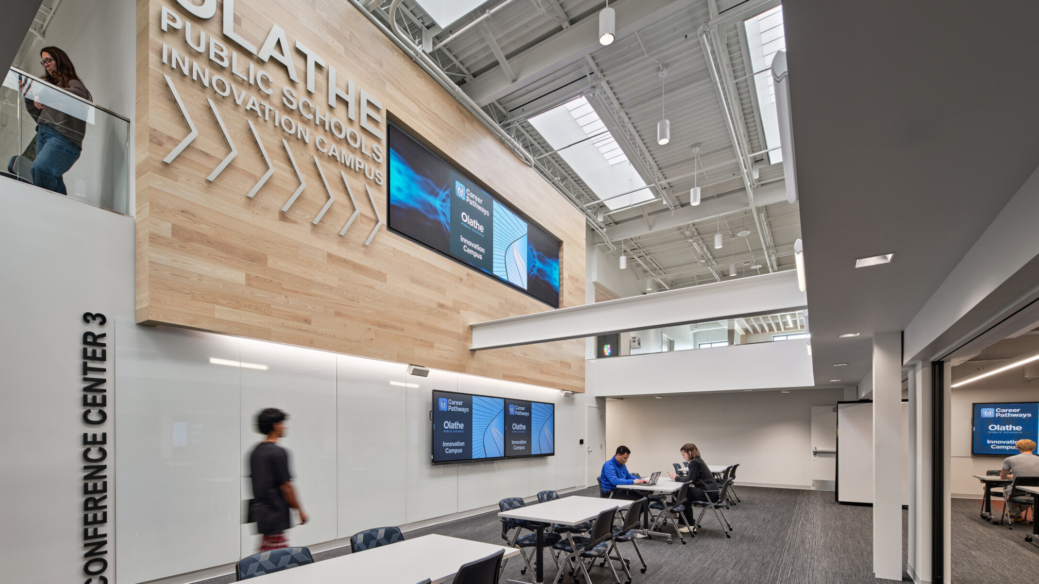 community study space in Olathe Innovation center with TVs on the wall and a communal seating space in the background