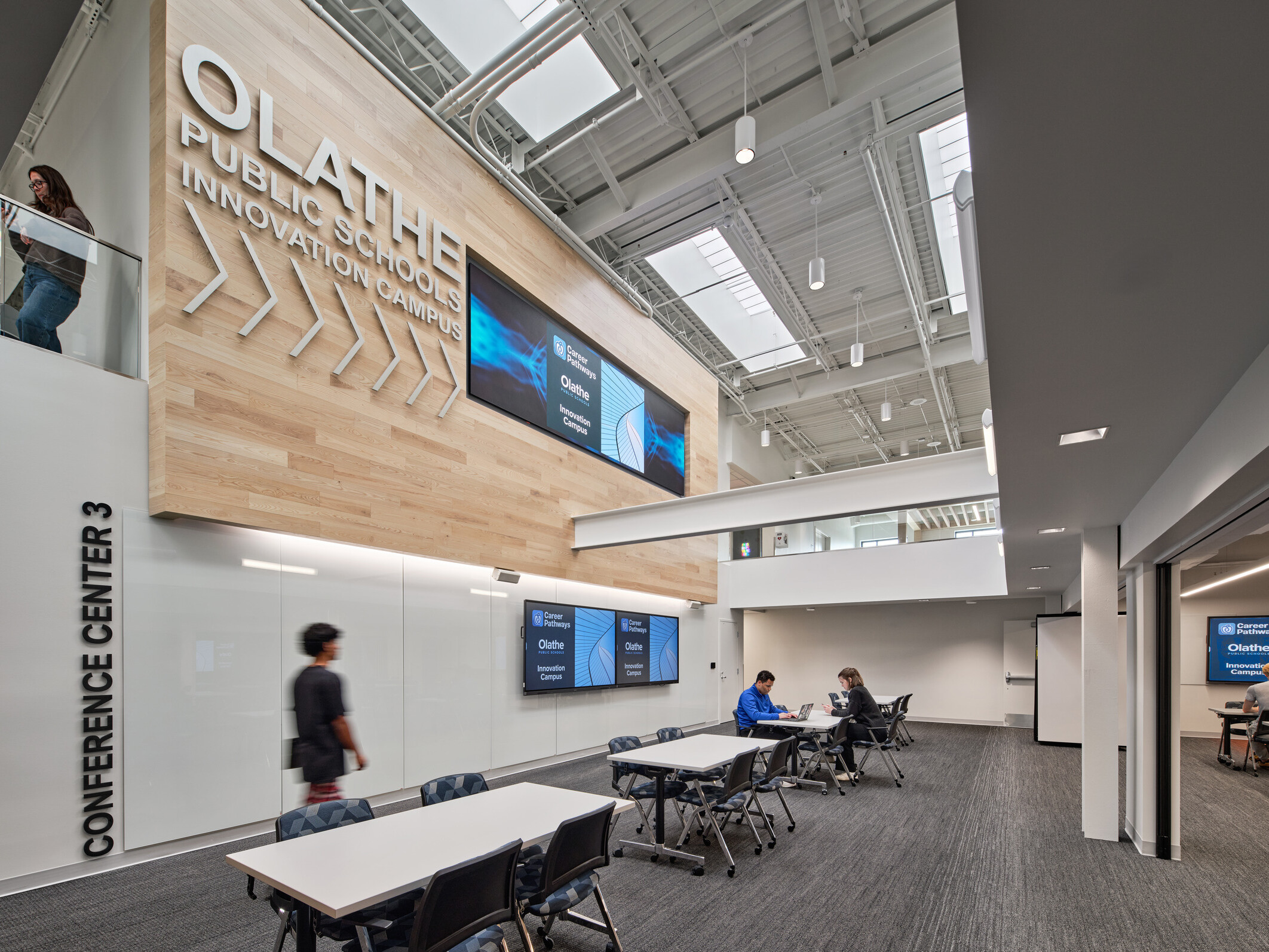 community study space in Olathe Innovation center with TVs on the wall and a communal seating space in the background