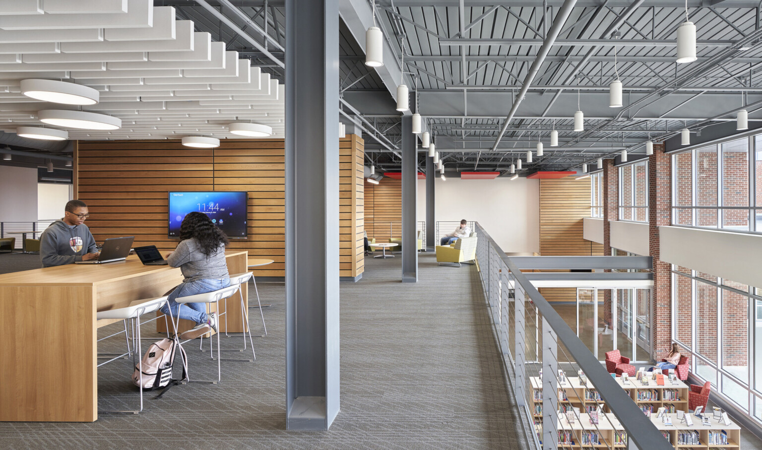 Seating areas on 2nd floor with wood panel accent walls overlooking 1st floor library. Double height windows on right wall Seating areas on 2nd floor with wood panel accent walls overlooking 1st floor library. Double height windows on right wall