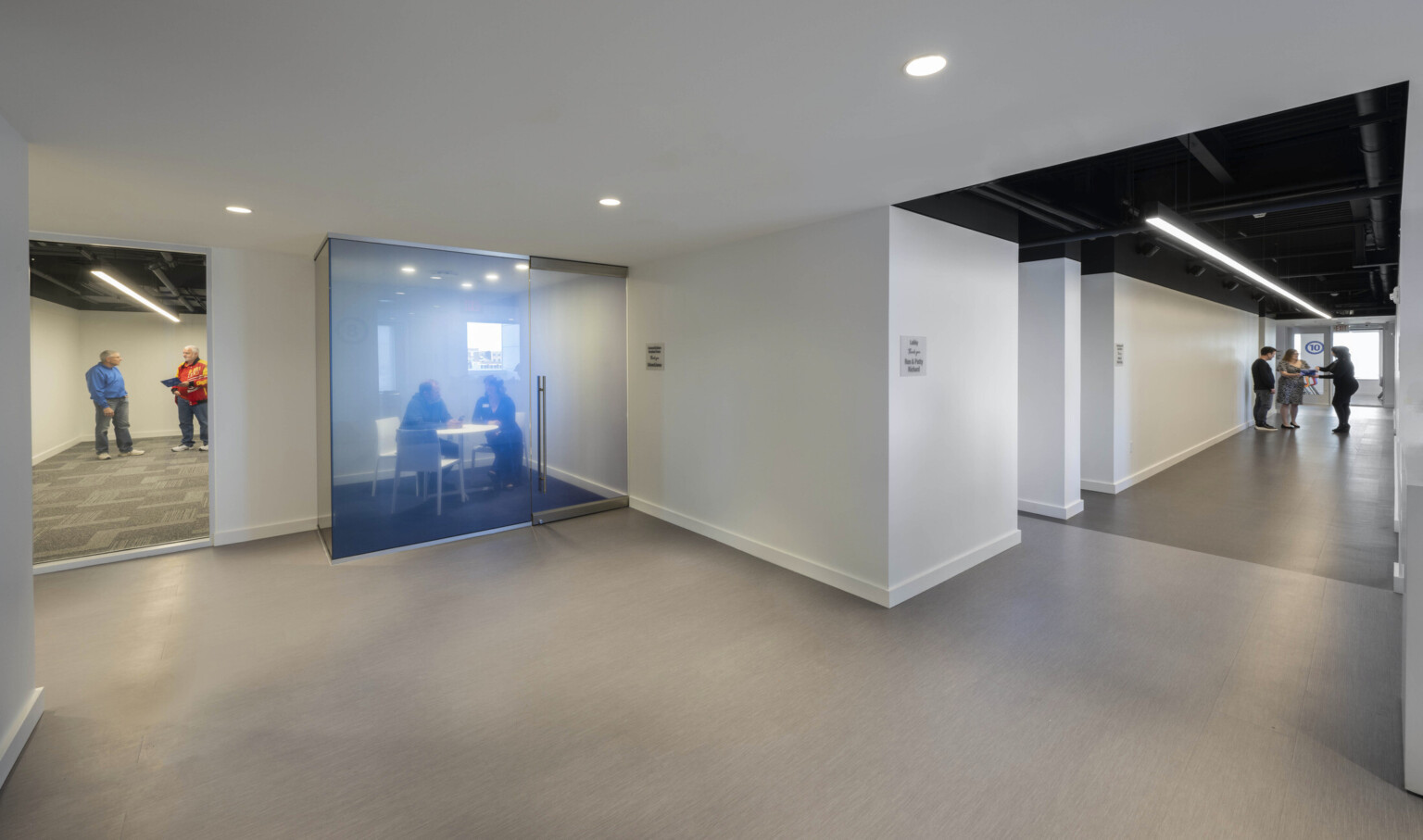 Indoor conference and meeting room area with private room with floor to ceiling glass walls, glass enclosure, on the corner