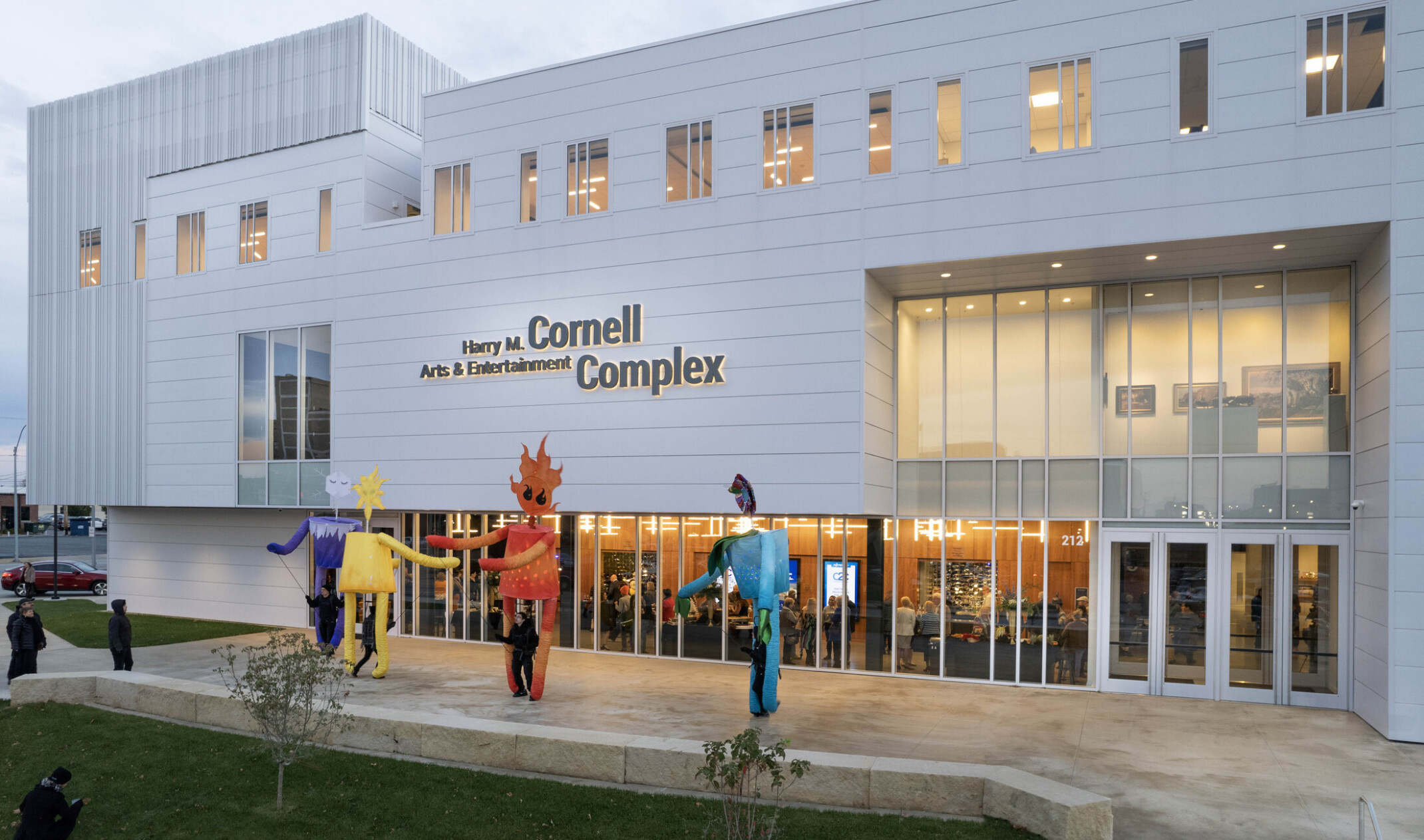 front entrance to Cornell Arts and Entertainment complex building; white multi-facade building with colorful art sculptures in front