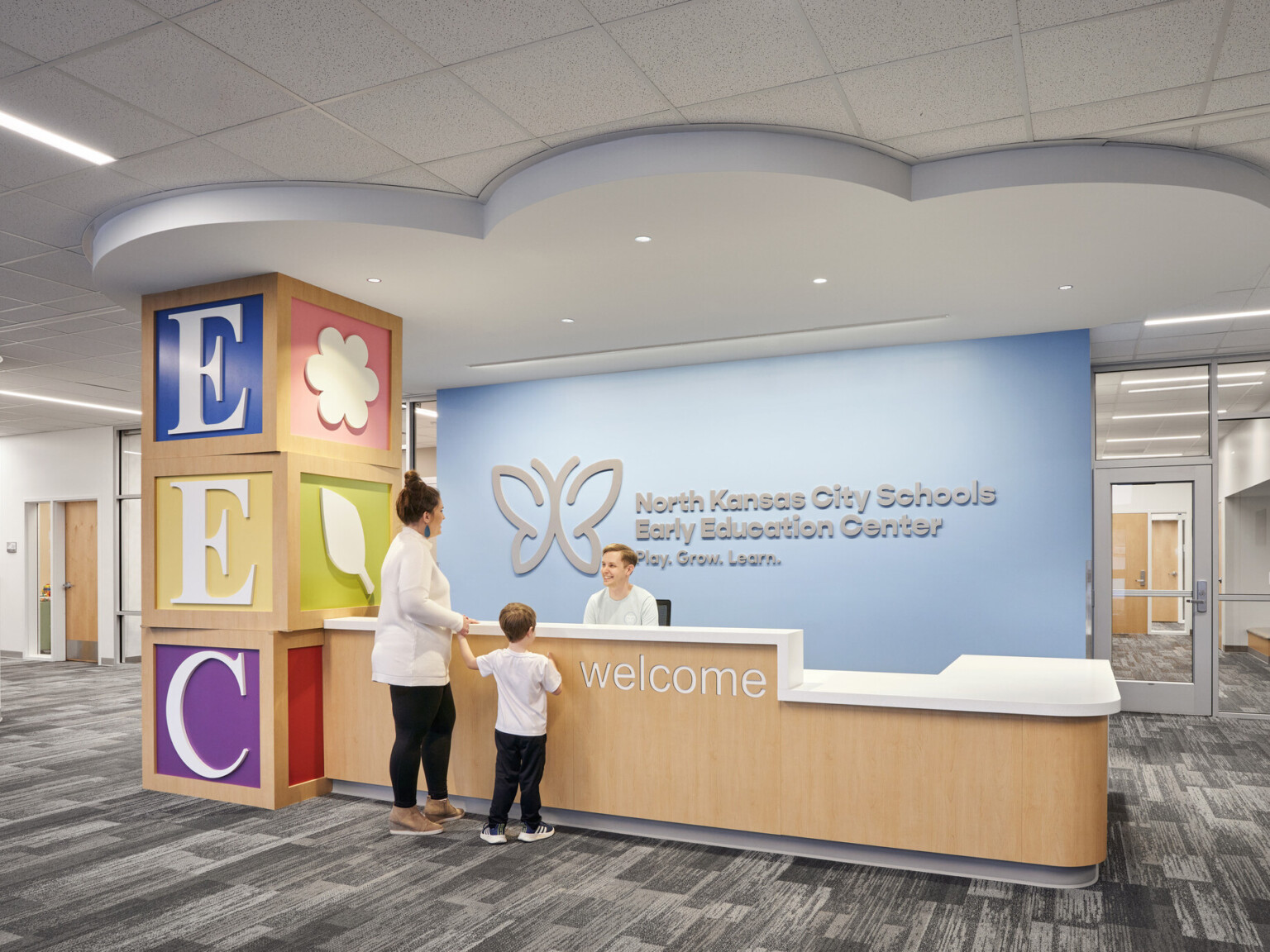 welcome desk in front of a blue wall and cloud formation on ceiling at the North Kansas City Early Education Center
