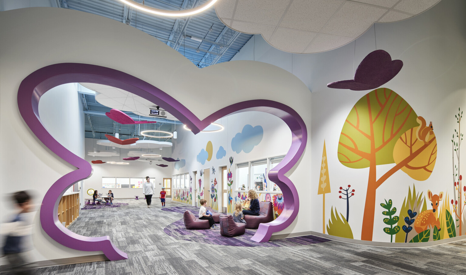 North Kansas City Early Education Center interior hallway with bright mural of trees and abstract-shaped cutout in purple in hall