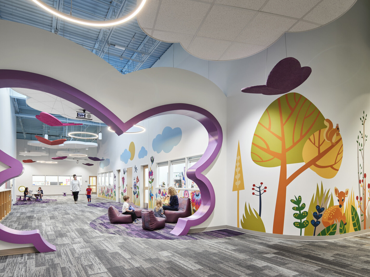 North Kansas City Early Education Center interior hallway with bright mural of trees and abstract-shaped cutout in purple in hall