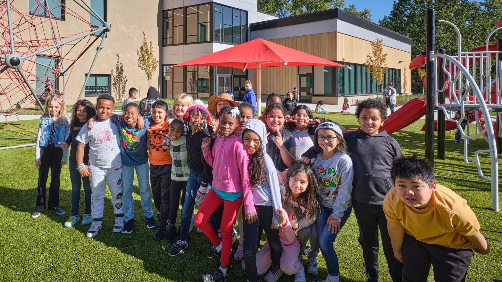 fourth grade students at Crestview Elementary School posed and facing the camera outside the school playground; modern tan building in the background