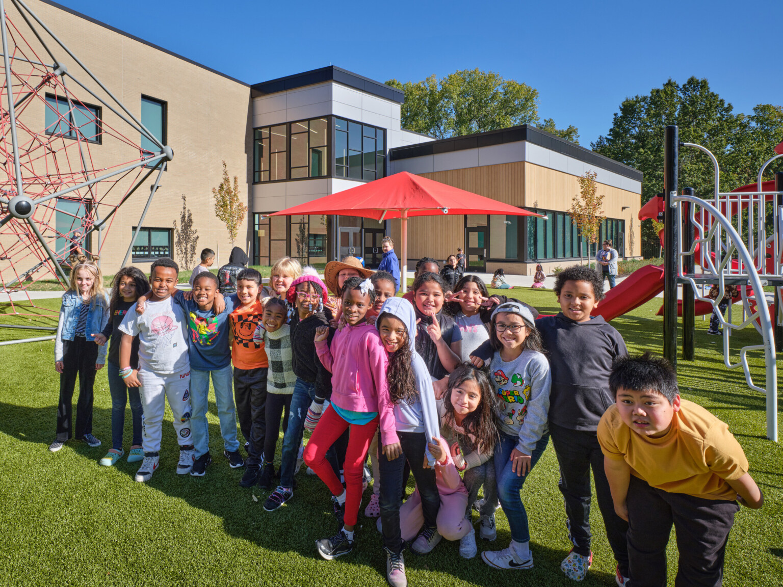 fourth grade students at Crestview Elementary School posed and facing the camera outside the school playground; modern tan building in the background