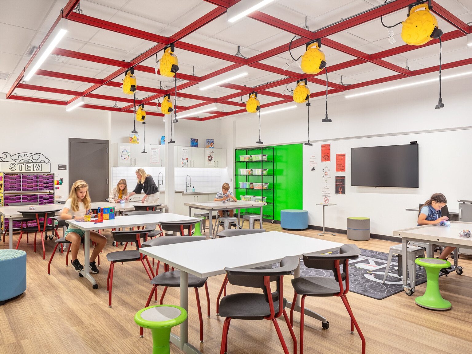 Elementary School with flexible learning spaces and seating, power cords hang overhead, STEM activities