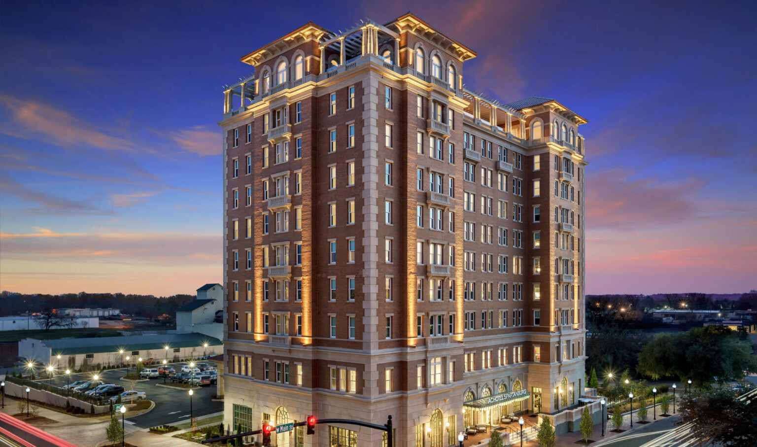 Exterior of building from aerial corner view. Main entry is to the right, with a parking lot behind the 10 story building