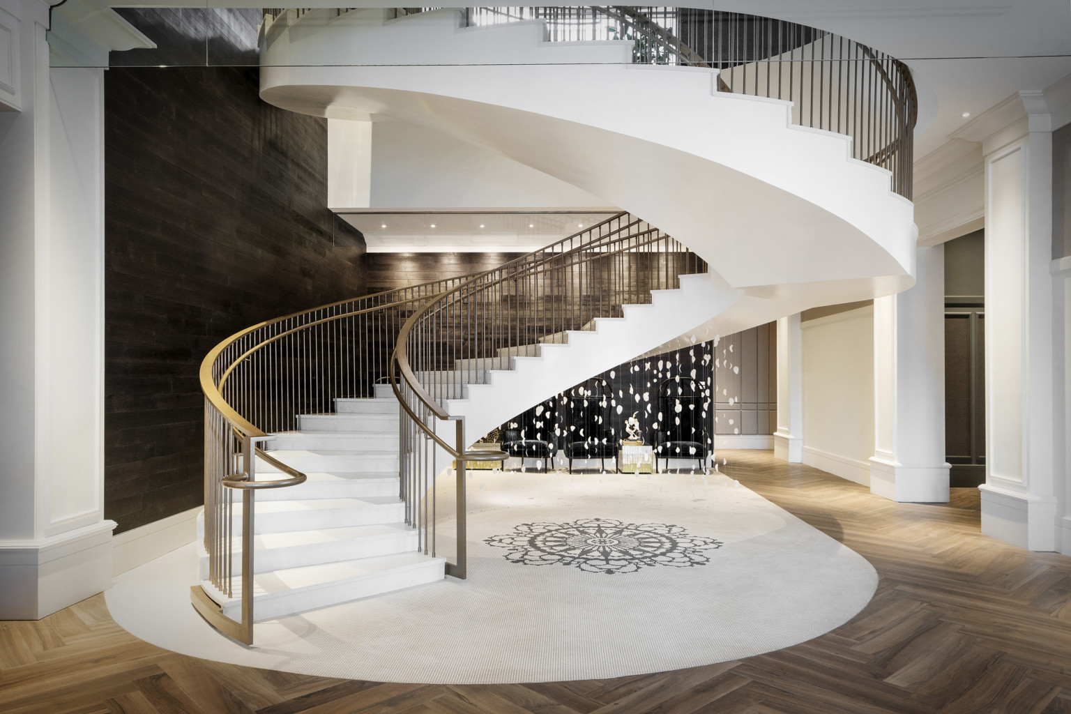grand stair at The Elizabeth Hotel, Autograph Collection by Marriott. White spiral stairs with abstract art hanging in center grand stair at The Elizabeth Hotel, Autograph Collection by Marriott. White spiral stairs with abstract art hanging in center