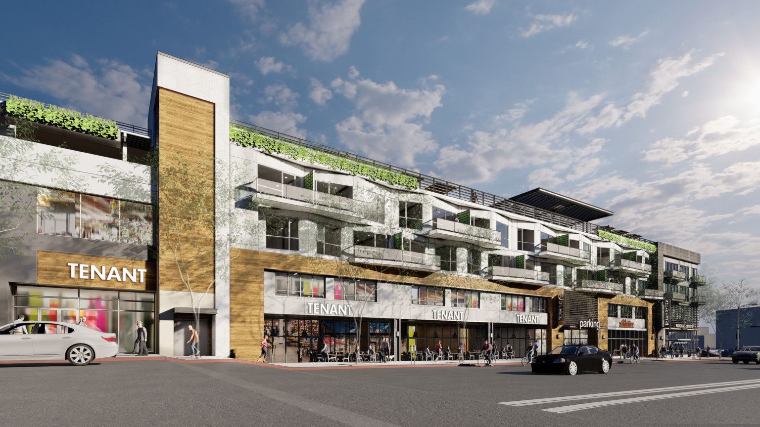 8550 Santa Monica Blvd viewed from street. Grey and brown 3 story building with greenery from roof and overhanging balconies