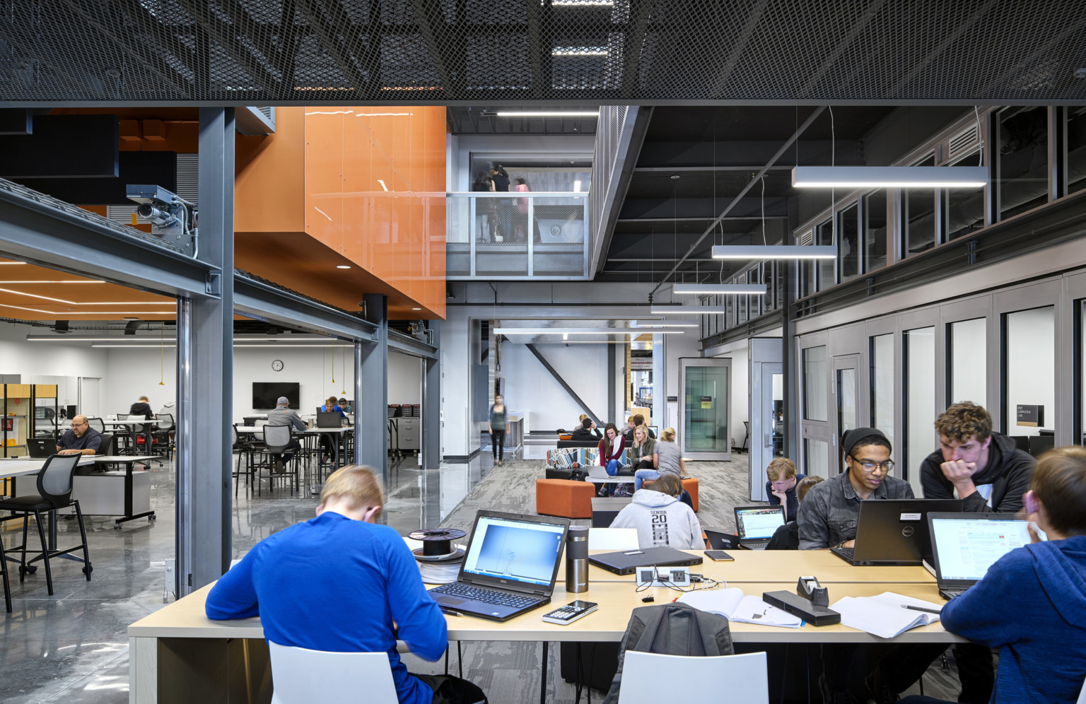 students collaborating in common space with exposed structure and views up to the second floor at the missouri innovation campus