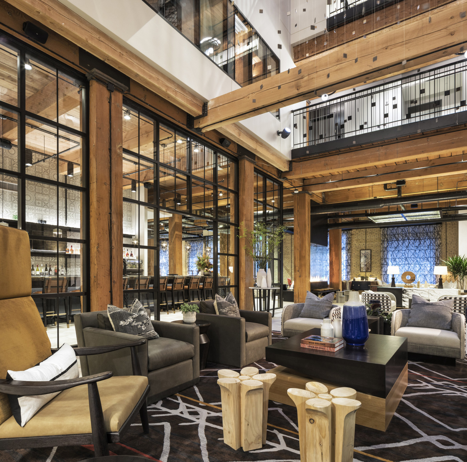 Dining area with wooden rafters, abstract hanging sculpture, and glass wall at Canopy by Hilton Minneapolis Mill District.