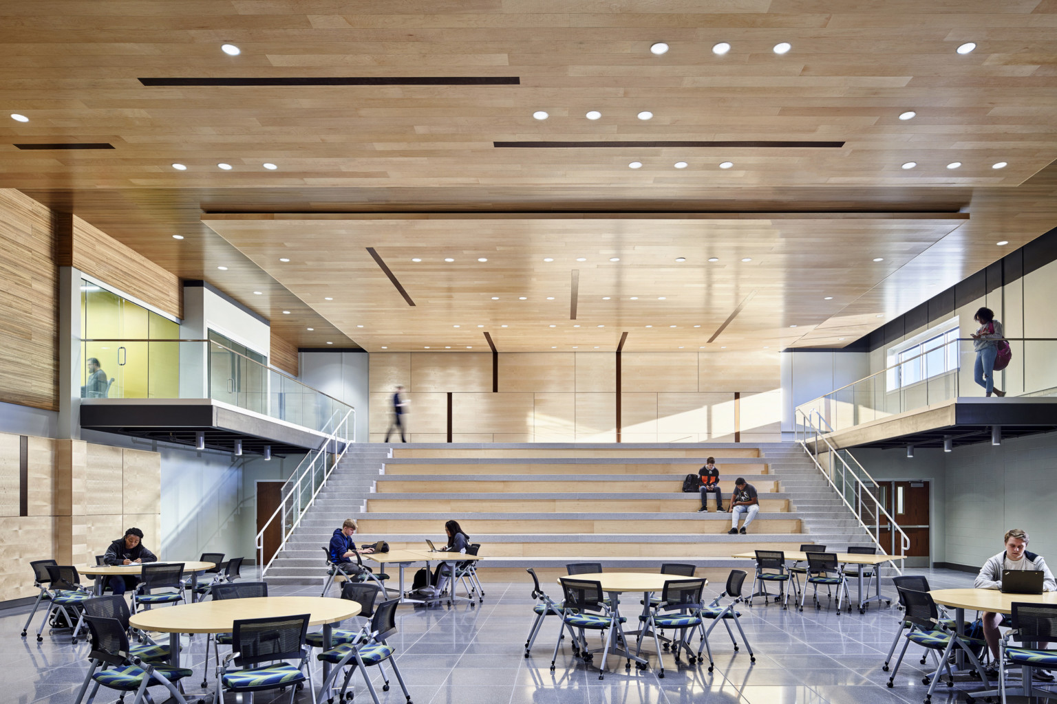 Learning staircase made from wood with ample lighting and learning pods on the side, dining area at the bottom at TCALC