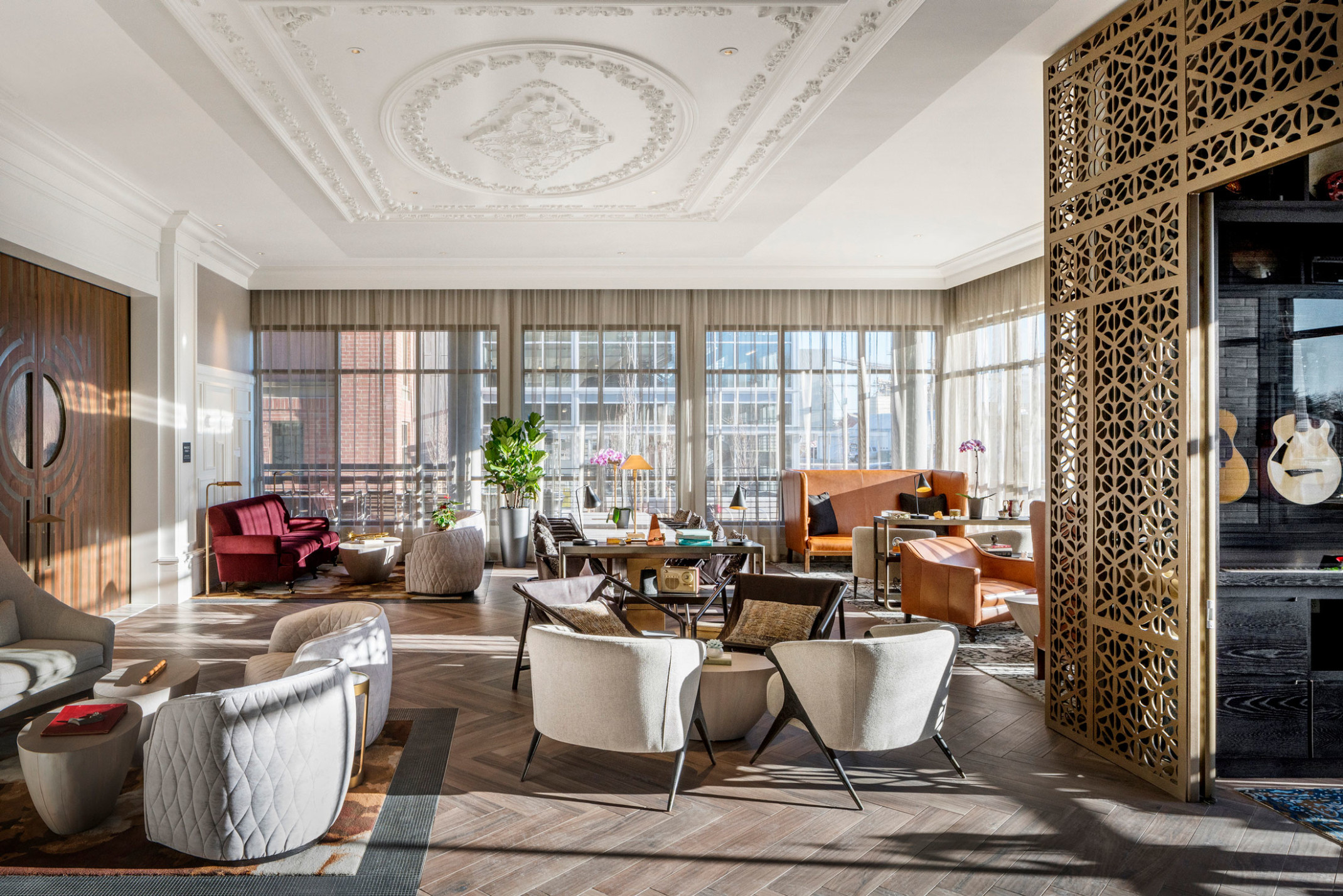 The Elizabeth Hotel, Autograph Collection lobby with white and orange seating, floor to ceiling windows, and crown molding