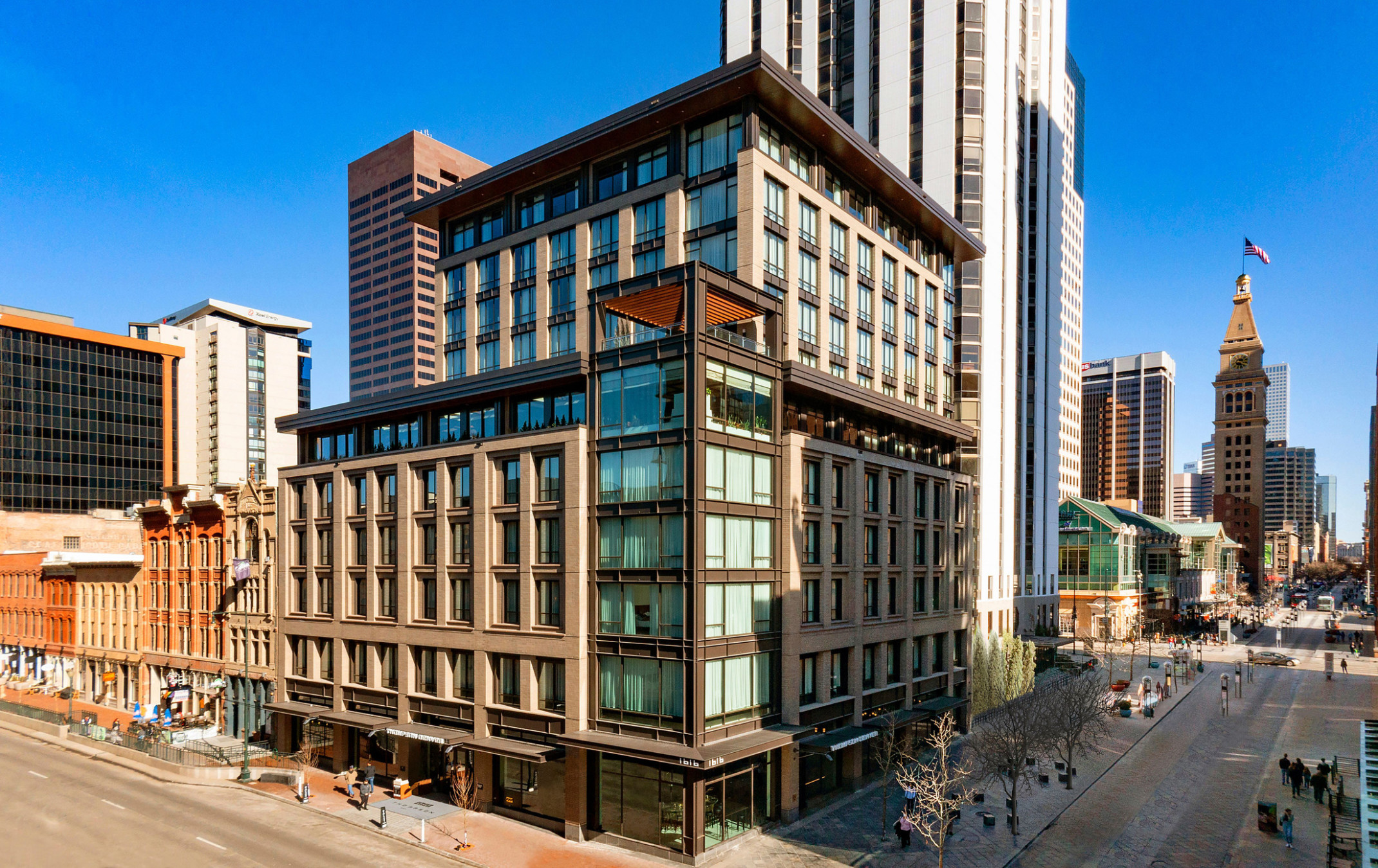 The Thompson Hotel Denver seen from corner with glass tower and stone facade on each side