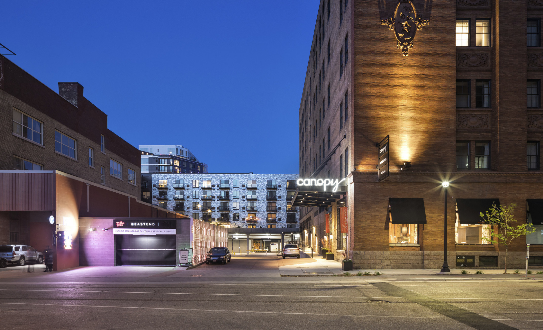 Canopy by Hilton Minneapolis Mill District sign illuminated over door of brick building with black awnings over windows