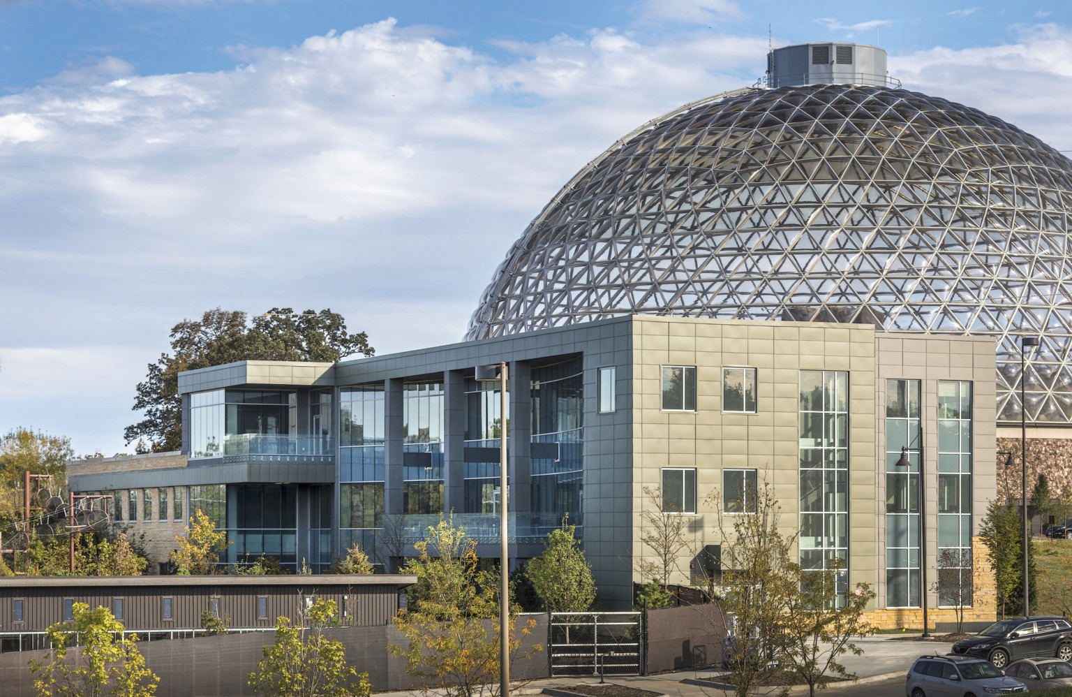 The Omaha Henry Doorly Zoo Education Building with large windows and wrapped facade in front of glass domed building