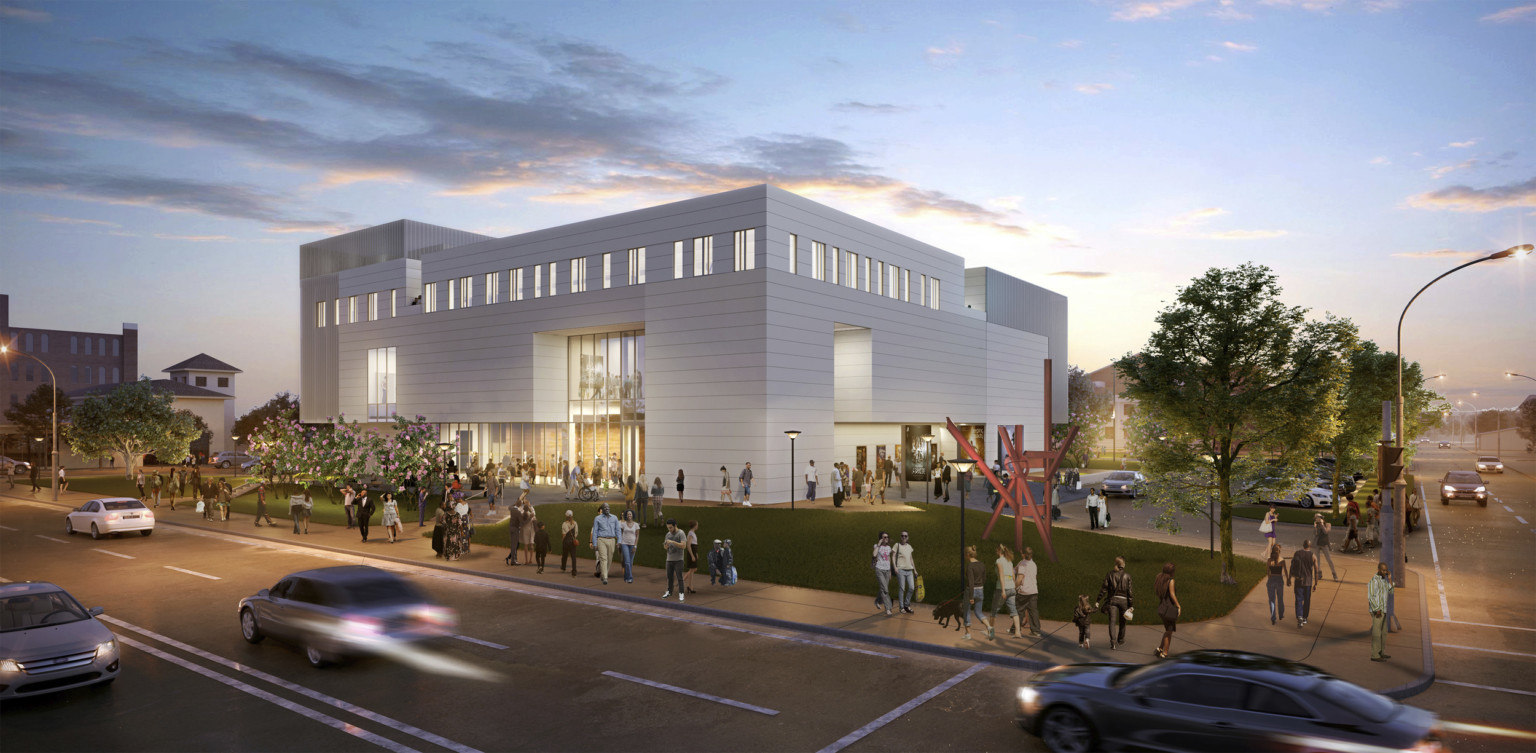 A white geometric multistory building with stripe panels illuminated in the evening surrounded by a crowd