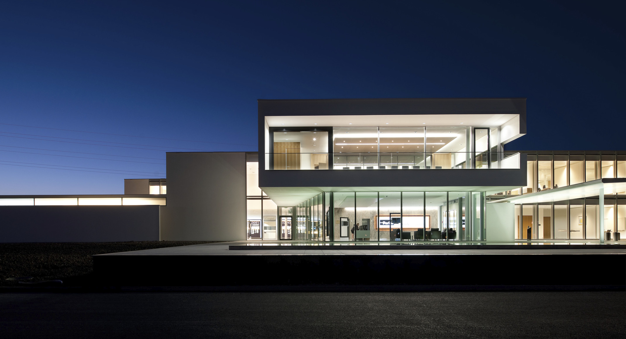 Parker Hannifin European Headquarters, a glass building with white wrapped facade illuminated from within at night