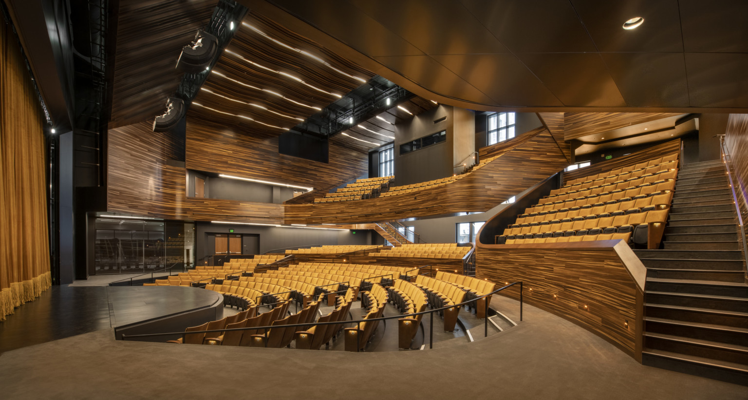 theater with wooden finishes and yellow seating, stairs on the right to balcony at Point Park University Pittsburgh Playhouse