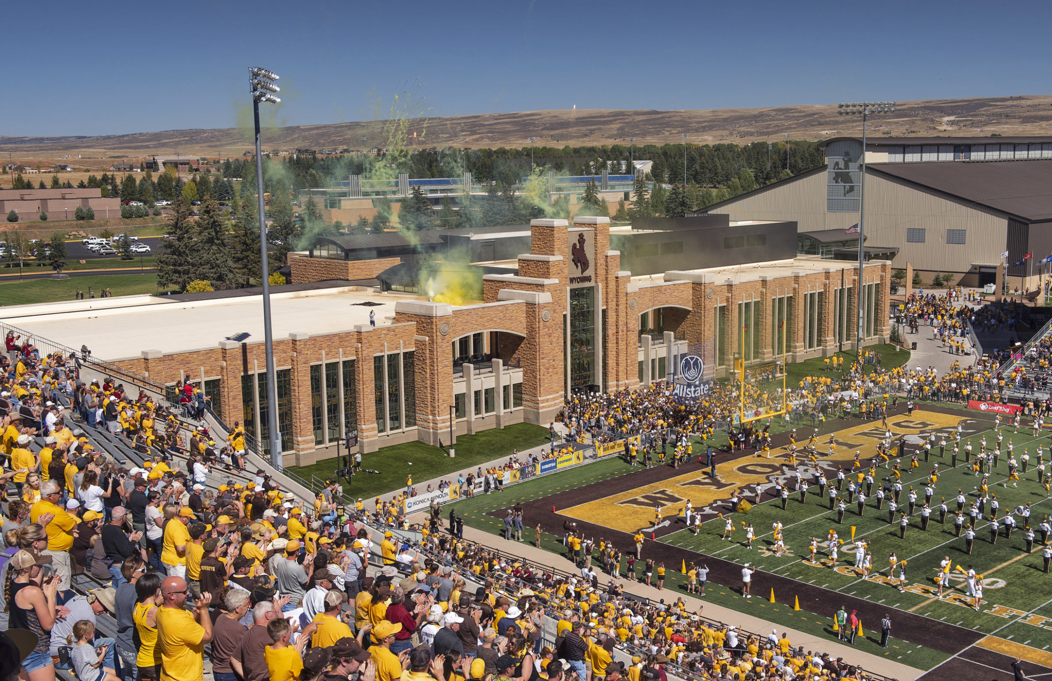 High Altitude Performance Center at the University of Wyoming seen from stands looking to stone building with yellow smoke